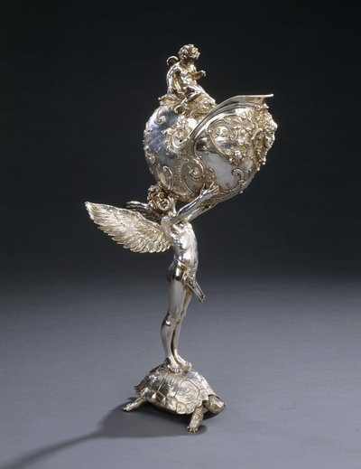 由弗朗兹·冯·斯塔克（Franz von Stuck）设计的WMF电镀青铜雕塑花架，仿佛是站在乌龟上飞翔的青年，举着鹦鹉螺的贝壳，约摄于1906年。 作者 弗朗兹·冯·斯塔克