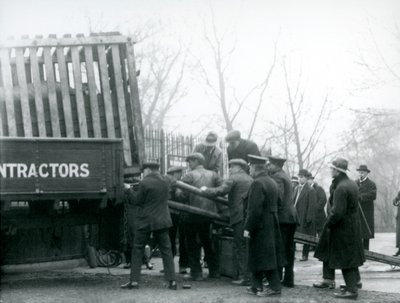 一群旁观者站在一旁，1924年在伦敦动物园，一名犀牛从一辆卡车上卸下，由饲养员卸下 作者 弗雷德里克·威廉·邦德