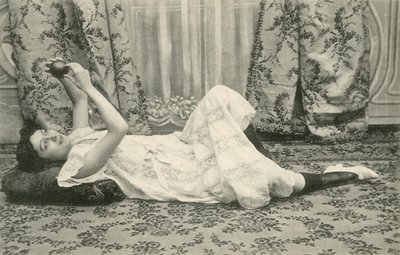 Girl, lying on the floor, holding a ball above her head (b/w photo) 作者 法国摄影师