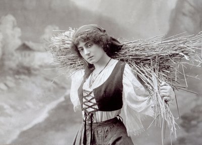 穿着传统服装的年轻妇女背着一捆稻草（黑白照片）。 作者 Giacomo Brogi