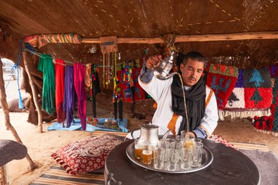 2019年，摩洛哥梅尔祖加附近沙漠中的厄格切比（Erg Chebbi），一名当地人正在为游客奉上薄荷茶（图 作者 艾拉·布洛克