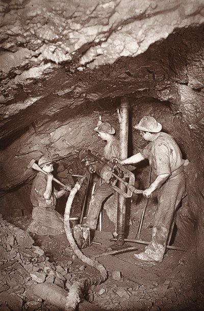 东池矿井的凿岩机末端，插图来自 J.C. Burrows 和 William Thomas 所著的《Mongst mines and miners, or Underground Scenes by Flash-Light》，1893 年出版（棕褐色照片）。1893 年（棕褐色照片） 作者 约翰·查尔斯·伯罗