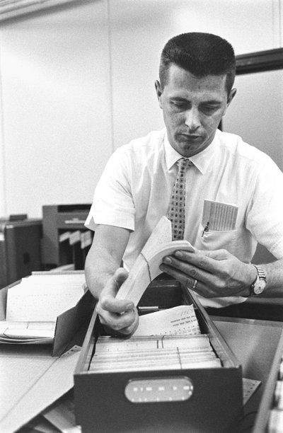 计算机操作员 Don Murray 正在操作 IBM 早期的数字计算机，该计算机使用打孔机。 作者 特德·斯皮格尔