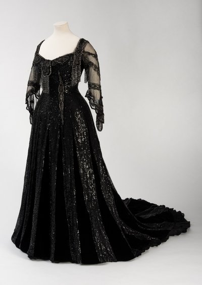 Black full length evening gown worn by Queen Alexandra, with bead and sequin decoration and incorporating Queen Alexandra’s signature black silk and gold lettered name tape, made by Barolet of Knightsbridge, London 1908-1910 (silk & velvet) 作者 不明