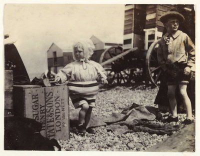 两个孩子在洗澡机旁，c 1895，两个孩子在海边的快照照片，站在海滩上的一群洗澡机中 作者 不明