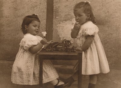 1937年，两个坐在桌子旁的年轻女孩。 作者 不明