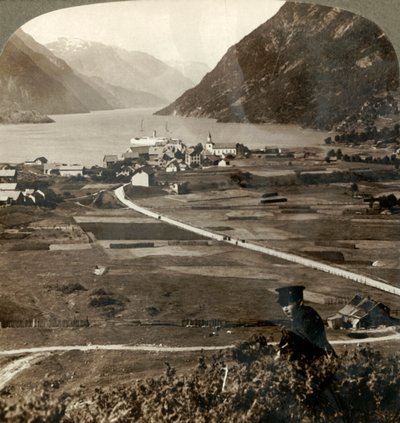 1905年，挪威北部奥德的村庄屋顶和阳光明媚的田野，穿过狭窄的山壁索夫峡湾。 作者 不明
