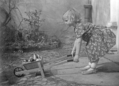 小女孩玩独轮车。 1931 年左右的摄影 作者 不明