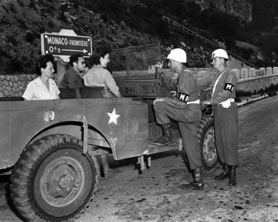 第二次世界大战（1939-1945） - 第二次世界大战（WWII 或 WW2）：摩纳哥法国里维埃拉附近 1945 年 6 月 30 日：美国里维埃拉游乐区 (USRRA) 的两名 Wacs 和客人与两名驻扎的美国陆军宪兵讨论 在 Mone 的边缘 作者 不明
