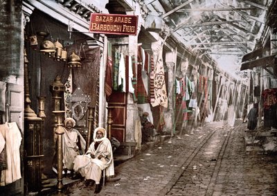 突尼斯的Le souc el Trouck：有法语标志的商店 "Bazaar arabic Barbouchi brothers"。1900年彩色照片。 作者 未知艺术家