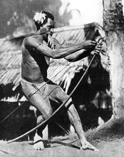 1936年，一个猎手在给他的弓上弦。 作者 世界各地的照片