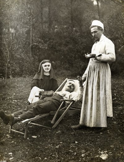 医生为一名受伤的男子把脉，由一名护士修女协助，约1900年（黑白照片）。 作者 . .