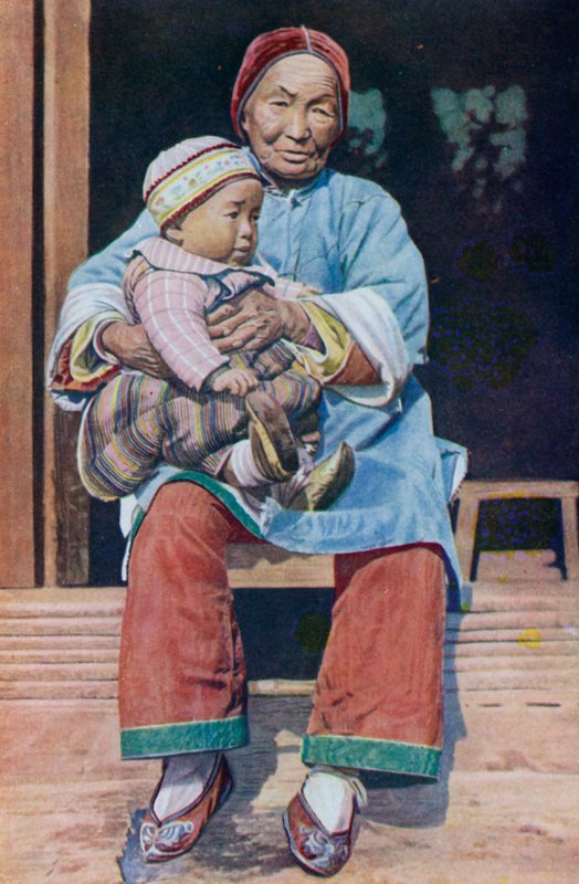 中国祖母，穿长裤，和孙子一起 作者 英国摄影师
