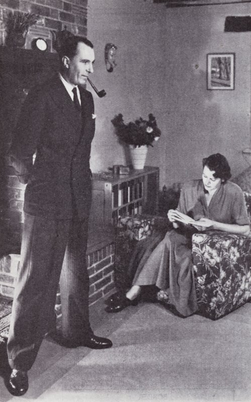 妻子念书，而丈夫为火取暖，约于1950年 作者 英国摄影师