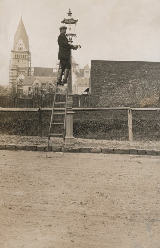 Man up a ladder fixing a street lamp (b/w photo) 作者 欧洲摄影师