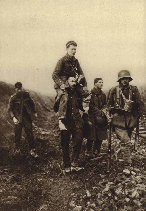 German infantryman with a leg wound being carried from the battlefield by British prisoners, World War I 作者 德国摄影师