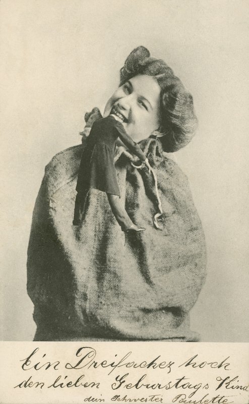 女人咬掉娃娃的头（黑白照片）。 作者 德国摄影师